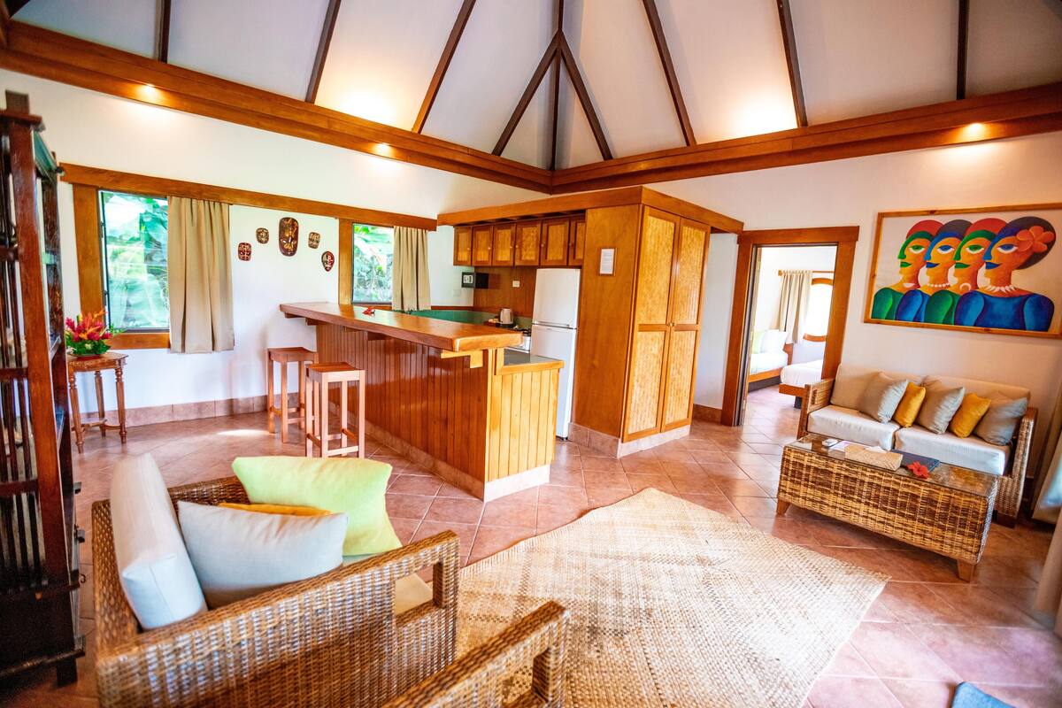 A spacious living area with a kitchen, a dining area, and a seating area with a sofa and chairs.
