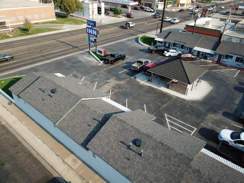 A parking lot with a gas station and a building with a sloped roof.
