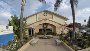 The Loma Linda Inn with a central courtyard, outdoor seating, and a fountain. - Loma Linda Inn (Loma Linda)