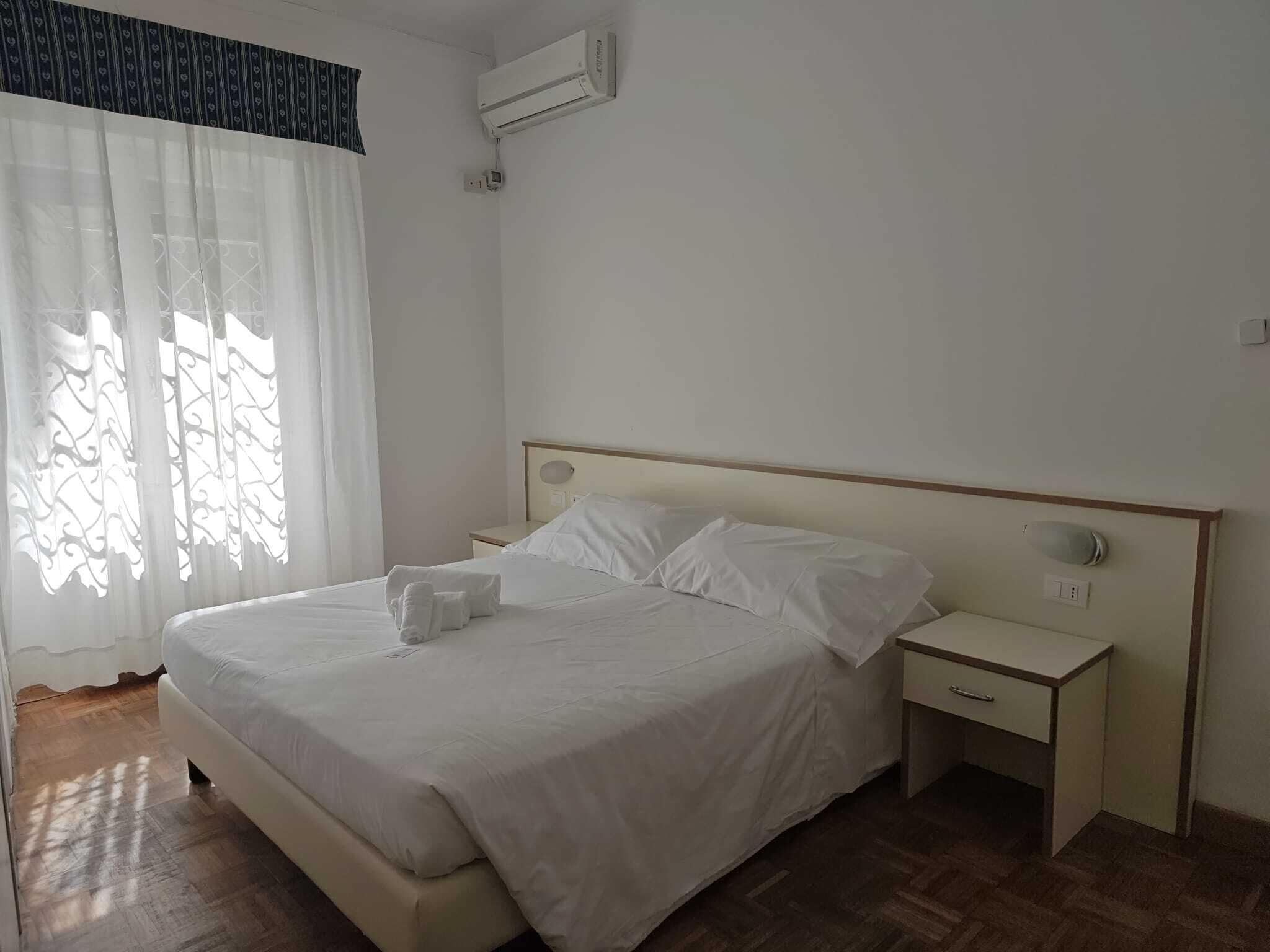Ein Schlafzimmer mit einem Bett, einem Nachttisch und einer Klimaanlage.