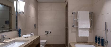 A modern bathroom with a bathtub, a shower, a toilet, and a sink.