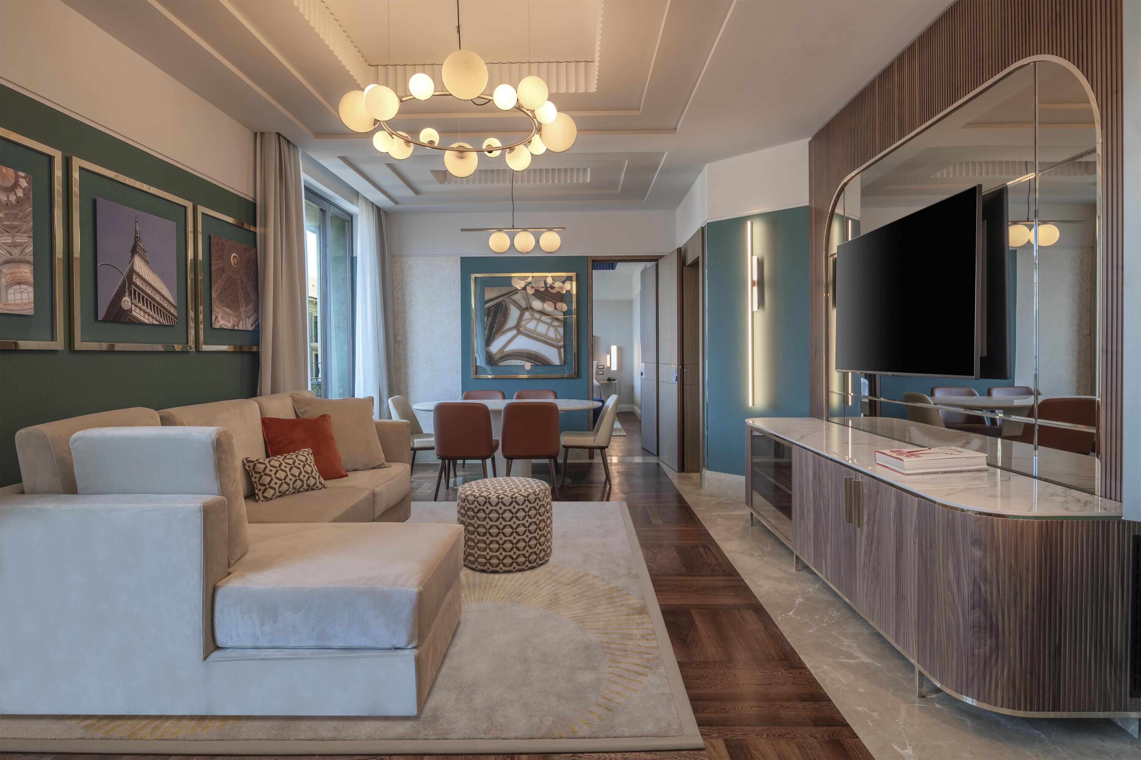 Una sala de estar moderna con un sofá, un reposapiés y un comedor con sillas y una mesa.