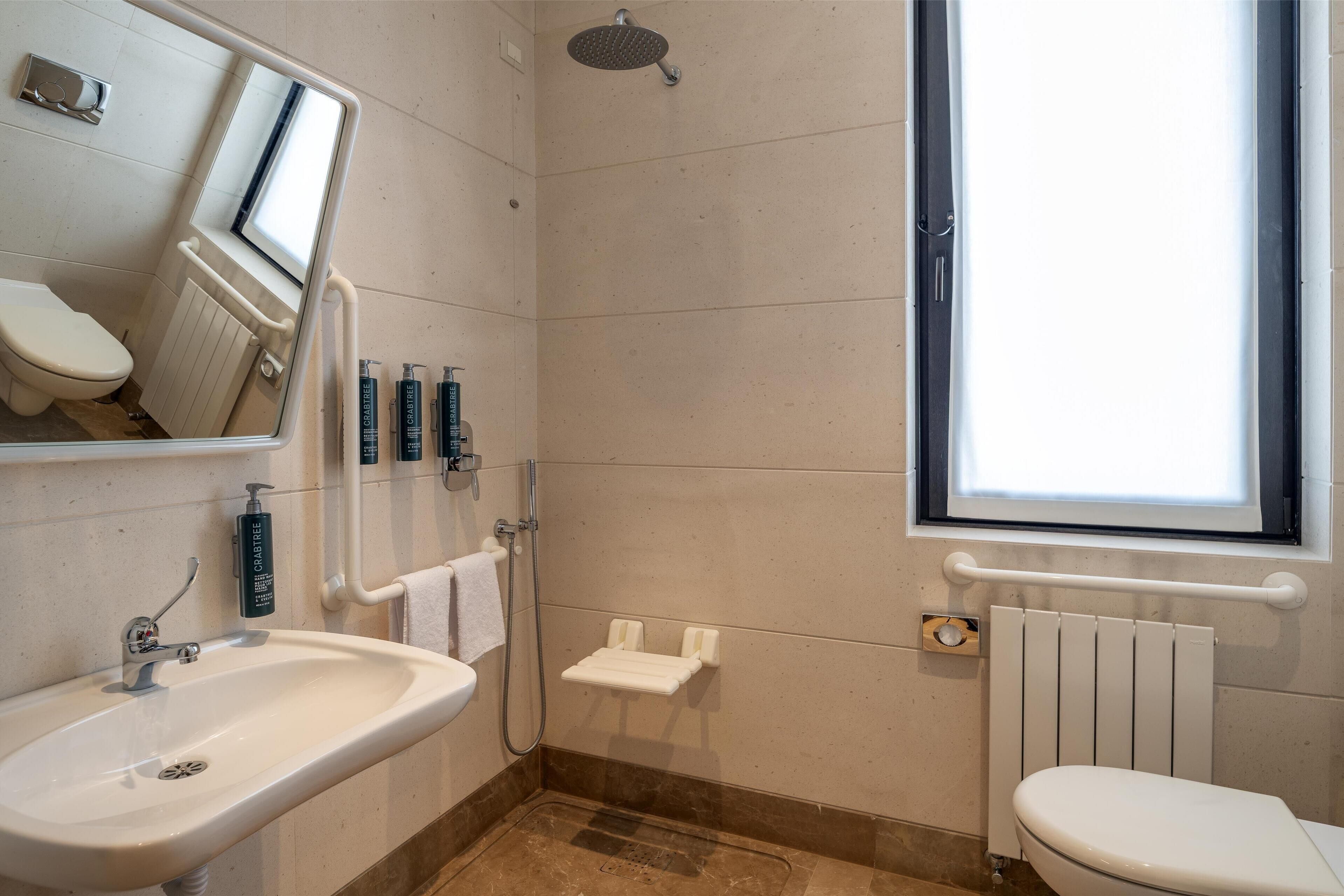 A bathroom with a sink, toilet, and shower.