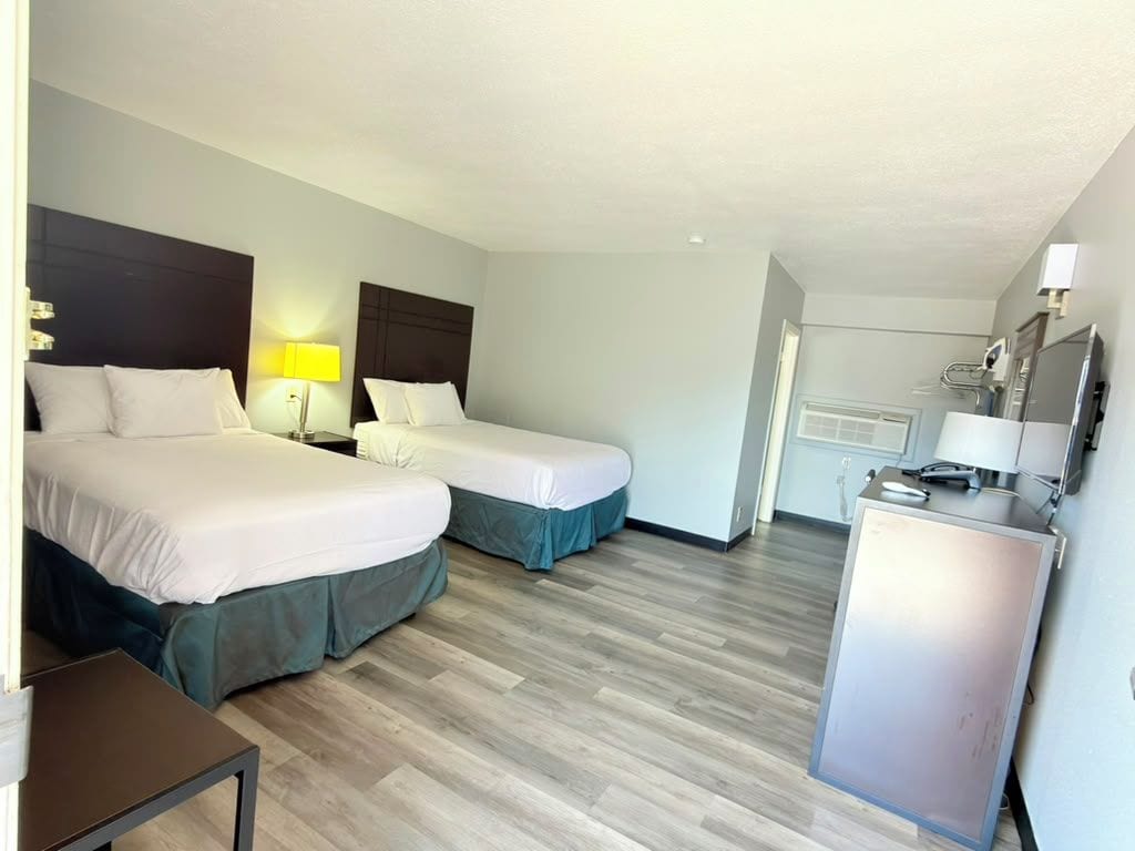 Ein Hotelzimmer mit zwei Betten, einem Schreibtisch und einer Minibar.