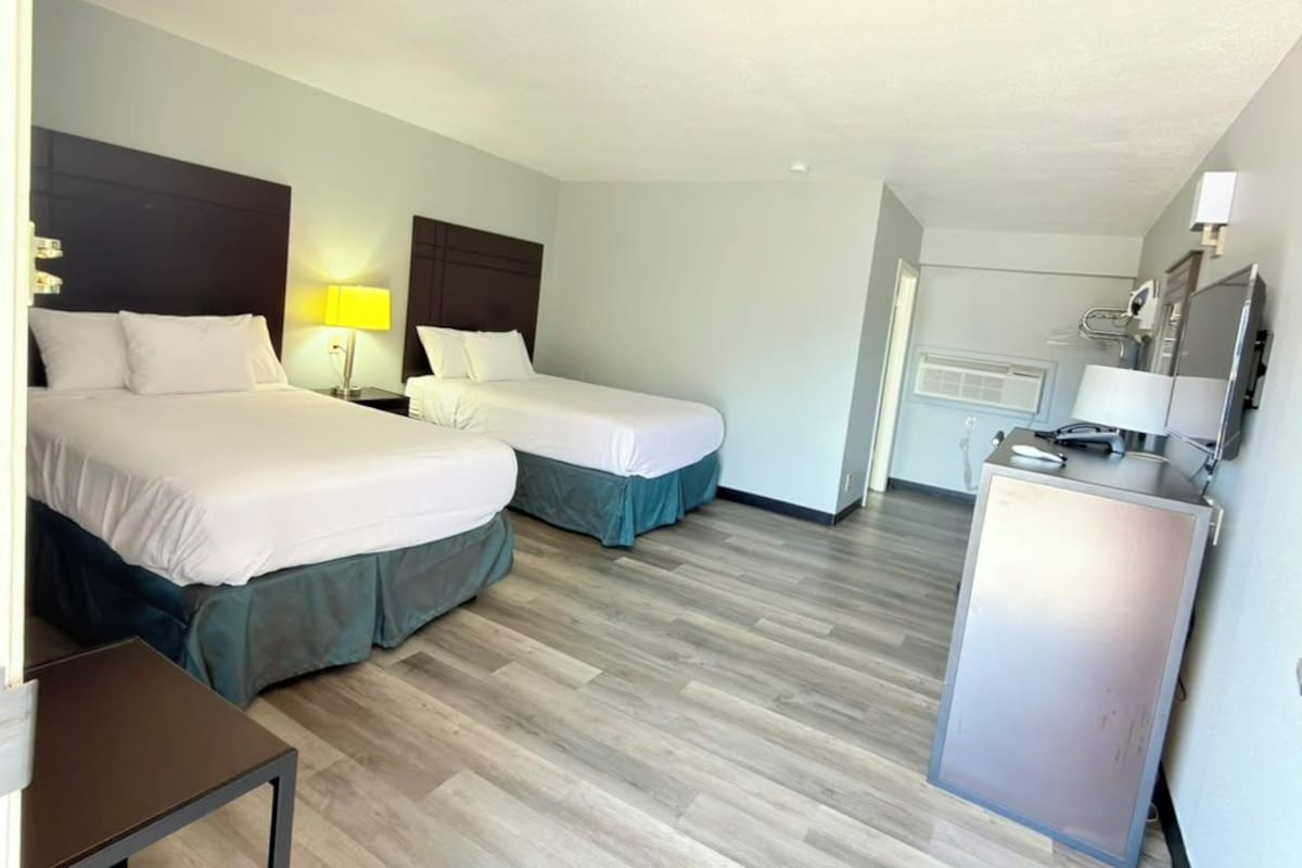 Habitación de hotel con dos camas, un escritorio y un minibar.