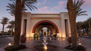 A hotel entrance with an arched doorway, palm trees, and a fountain. - Grand Rotana Resort & Spa (Sharm El Sheikh)