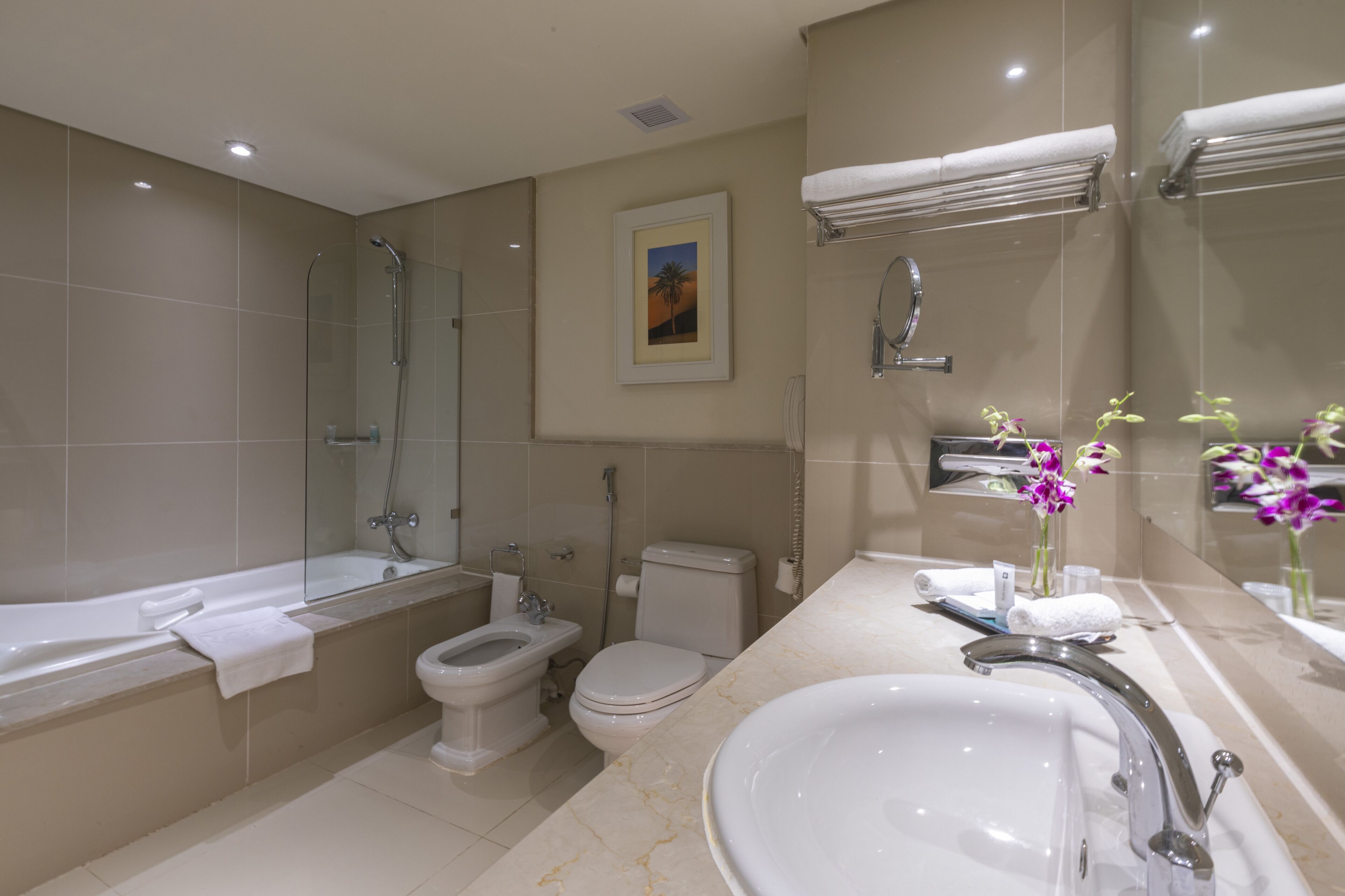 A modern bathroom with a bathtub, toilet, bidet, and sink.