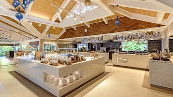 Un hall d’hôtel spacieux, doté d’un grand comptoir de réception en marbre, d’un éclairage moderne et d’un plafond haut orné de poutres en bois.