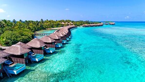 An overwater bungalows with thatched roofs, connected by walkways, in a clear turquoise sea. - Sheraton Maldives Full Moon Resort & Spa (Furanafushi Island)