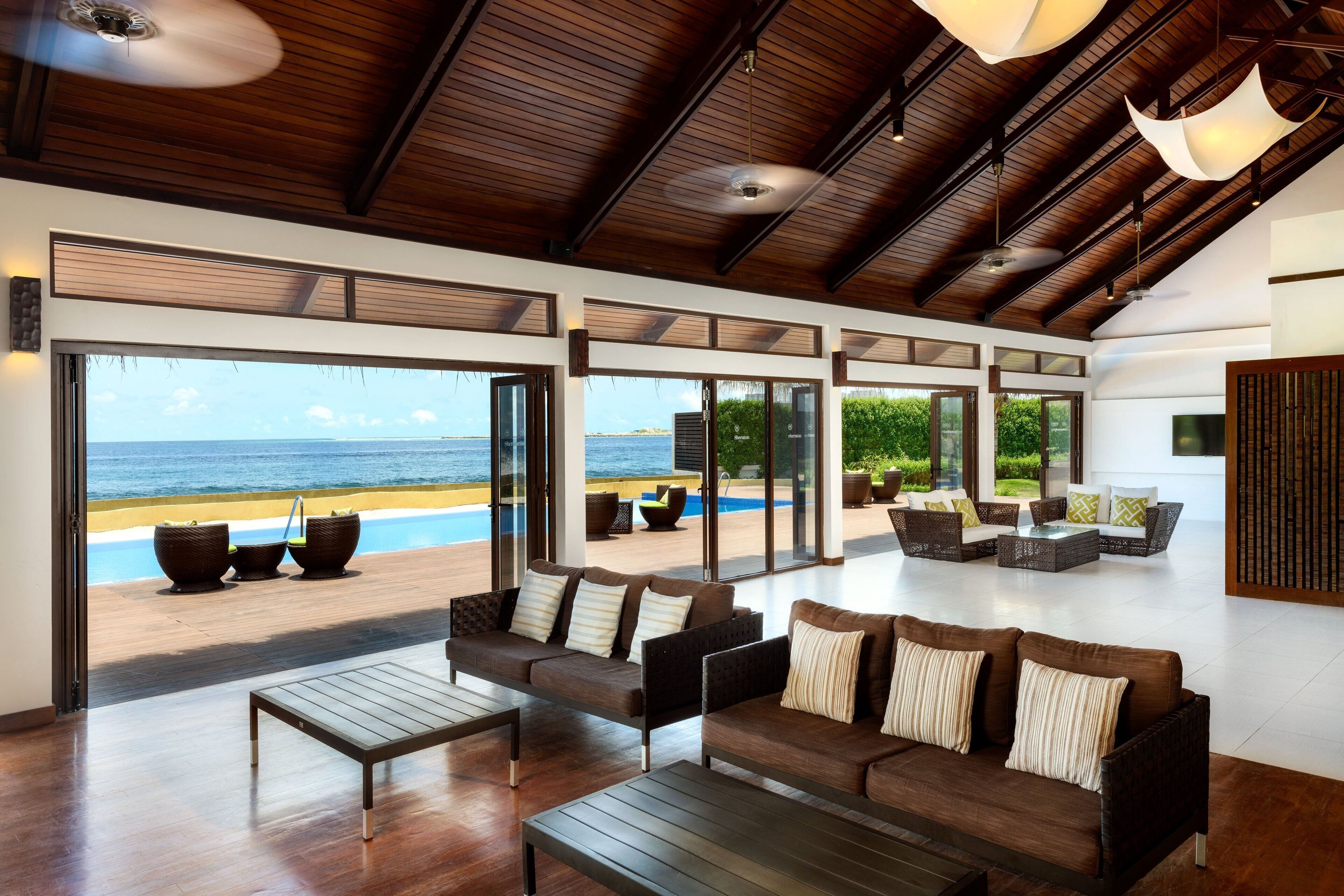 A spacious living area with a view of the ocean, furnished with sofas and a coffee table.