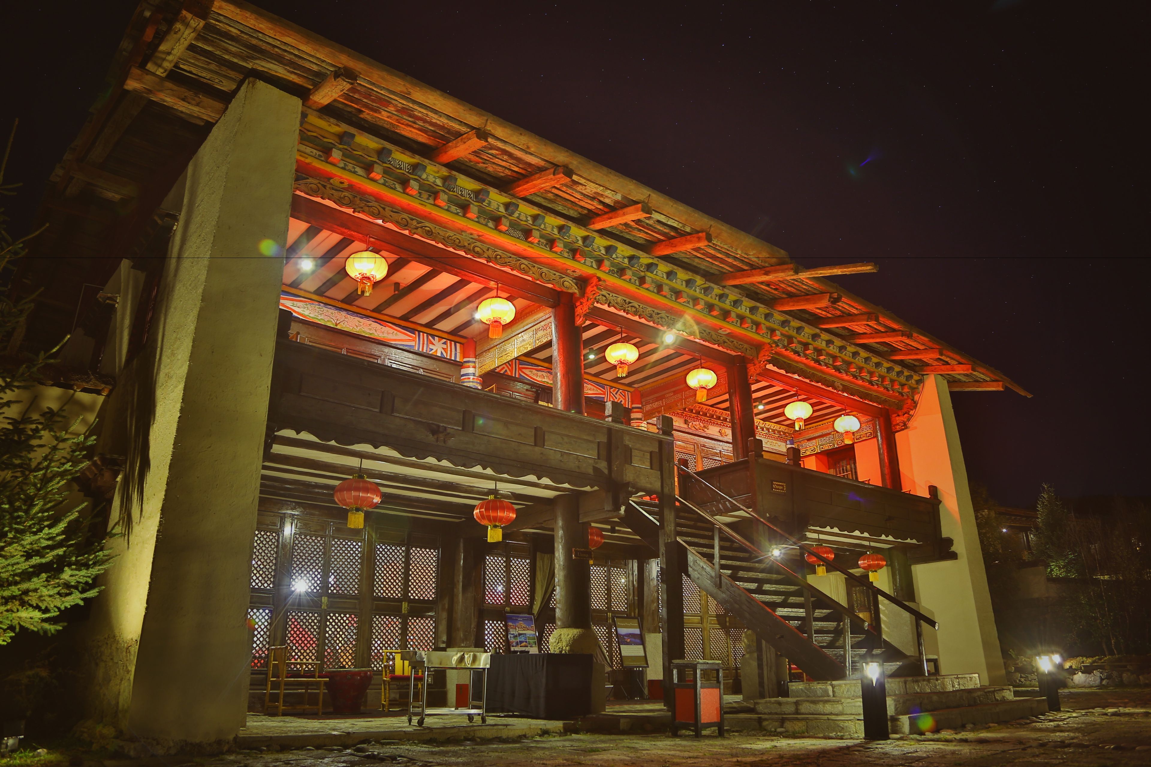 A traditional building with a wooden structure, a staircase, and lanterns.