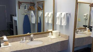 A bathroom with two sinks, a mirror, and a towel rack.