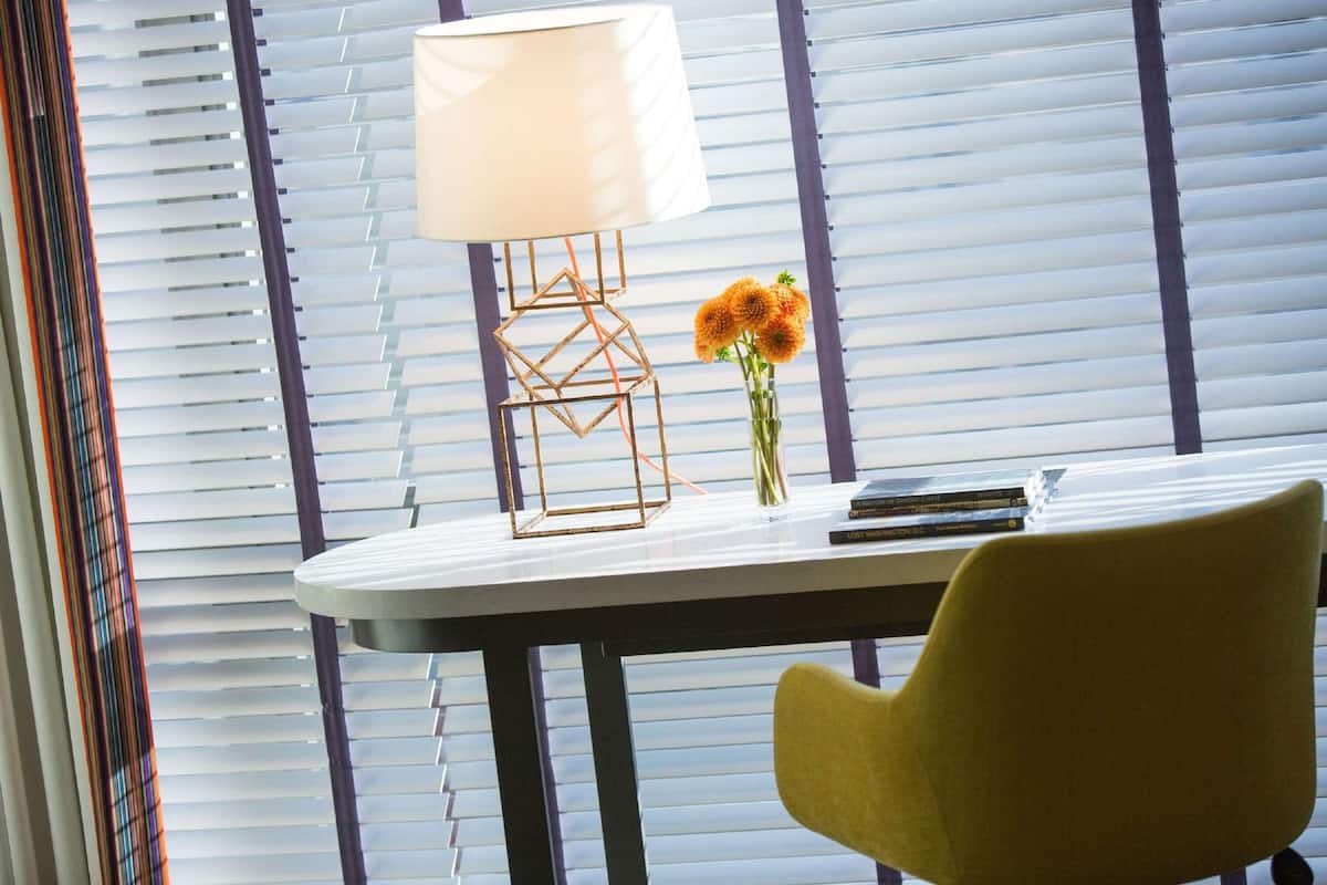 A modern room with a table, a lamp, and a chair.