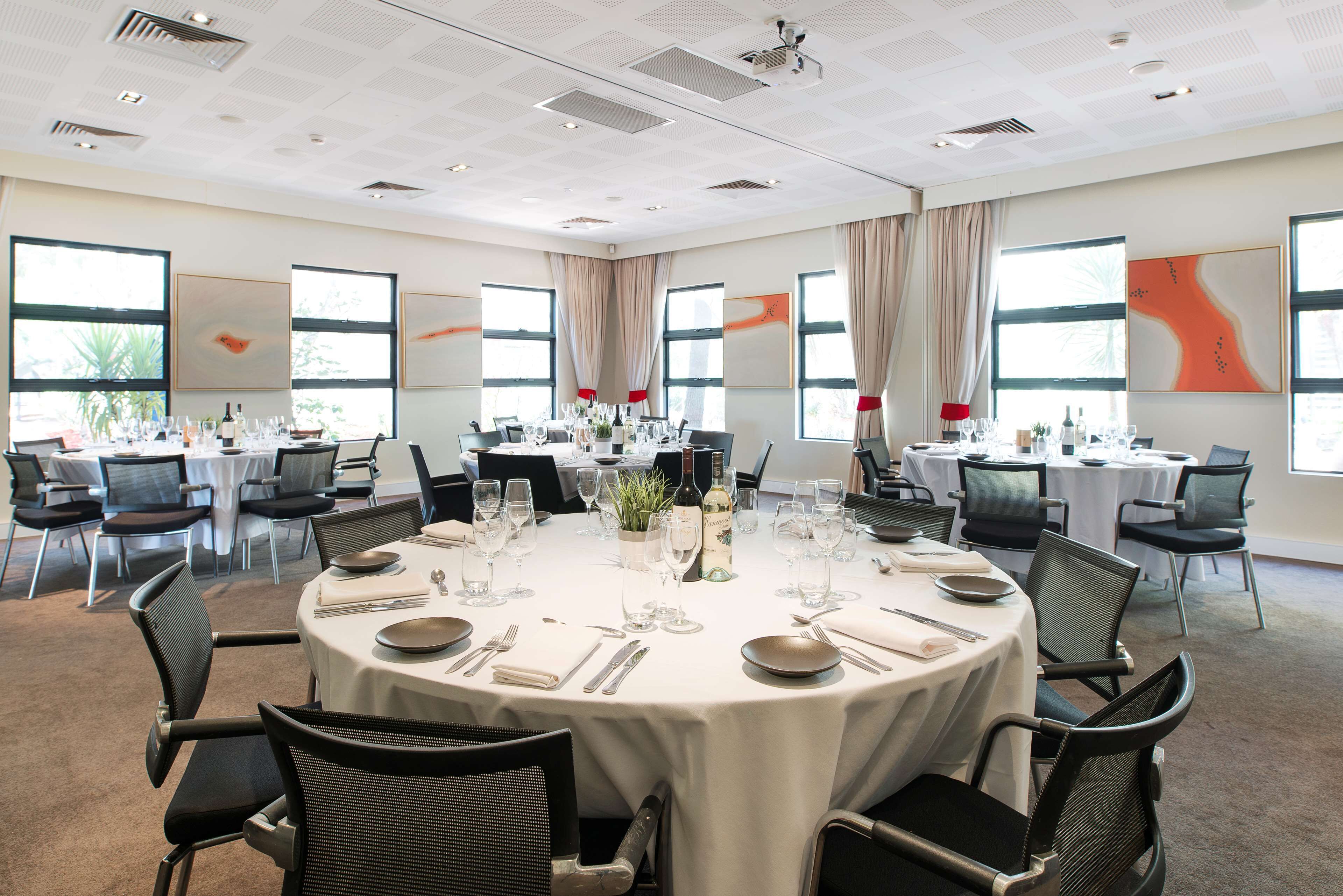 A conference room with round tables, chairs, and dining setup.