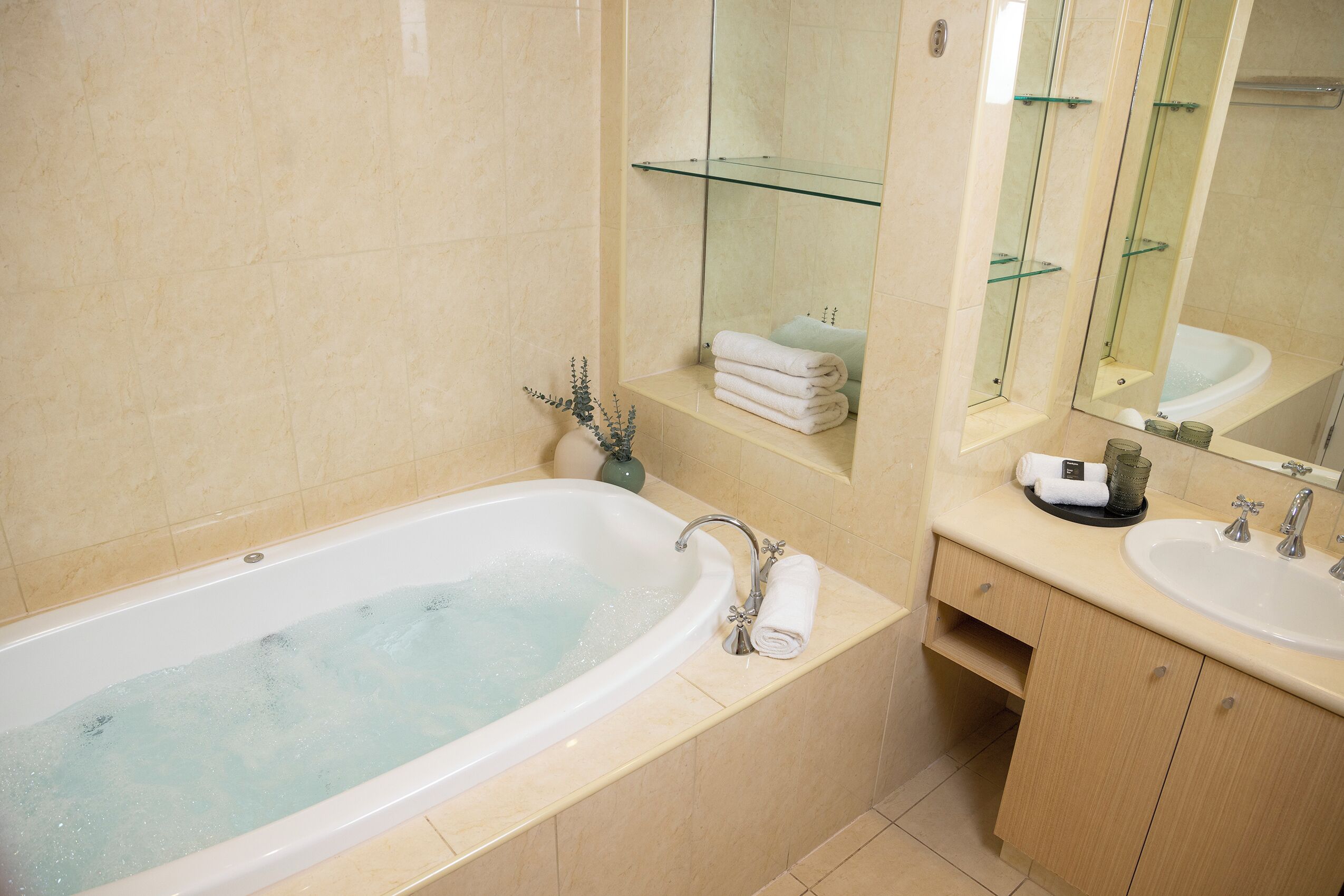 A modern bathroom with a bathtub, a sink, and a vanity.