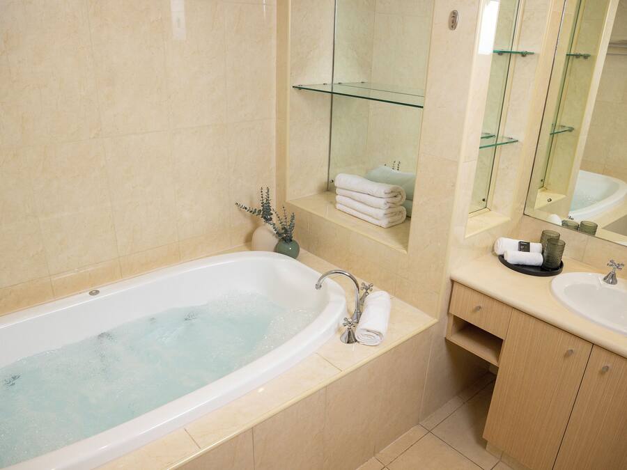 Un baño moderno con bañera, lavamanos y tocador.