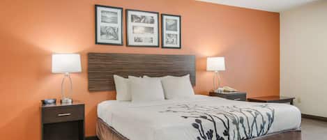 A hotel room with a large bed, two bedside tables, a nightstand, and a ceiling fan.