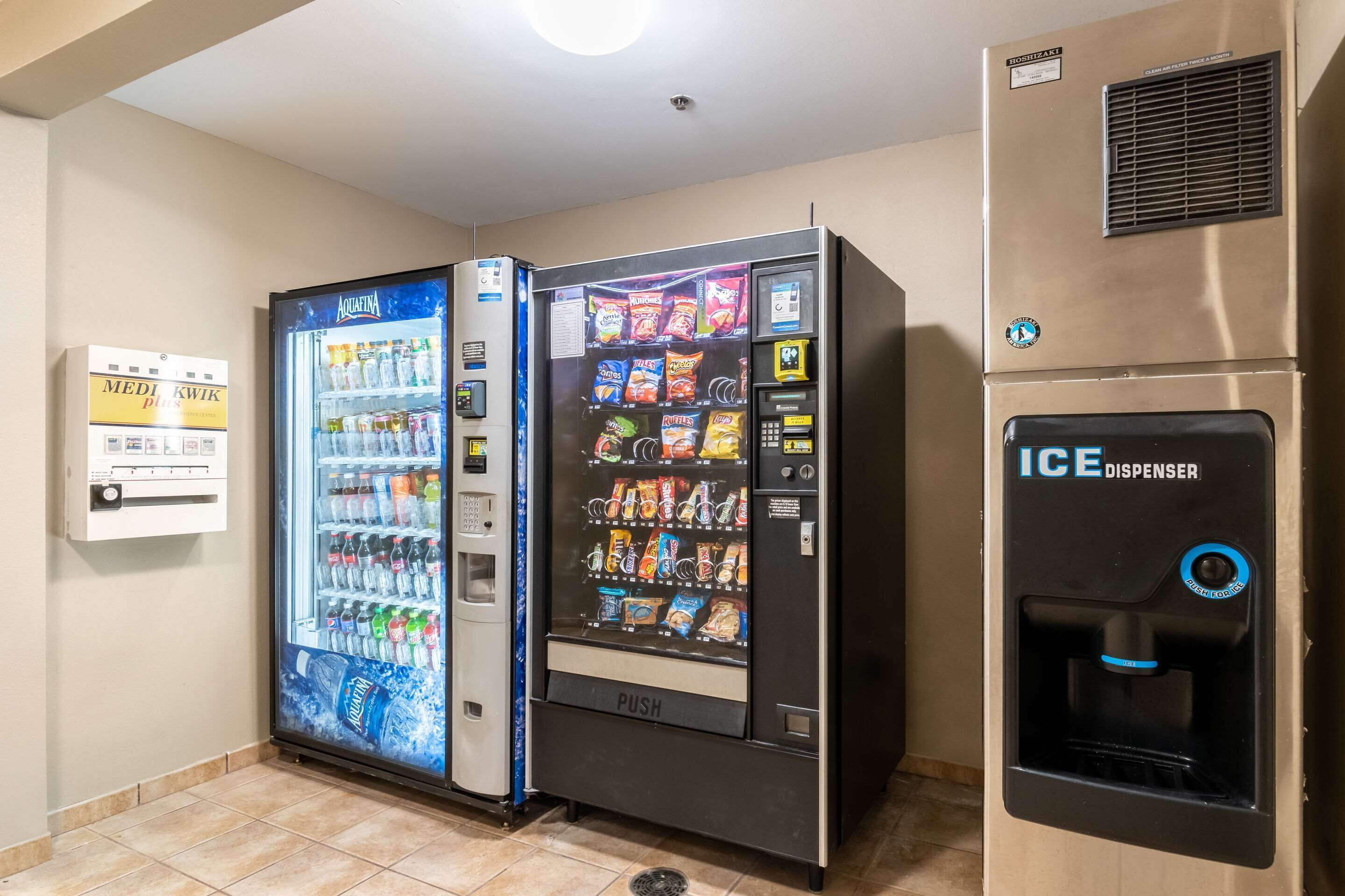 Zona de máquinas expendedoras con dispensador de agua y máquinas para aperitivos.