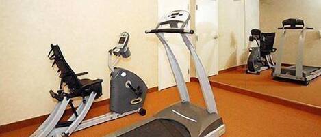 Un gimnasio con cintas de correr y equipo de ejercicio.