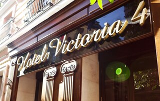 A hotel sign with the name "Hotel Victoria 4" and classical architectural details.