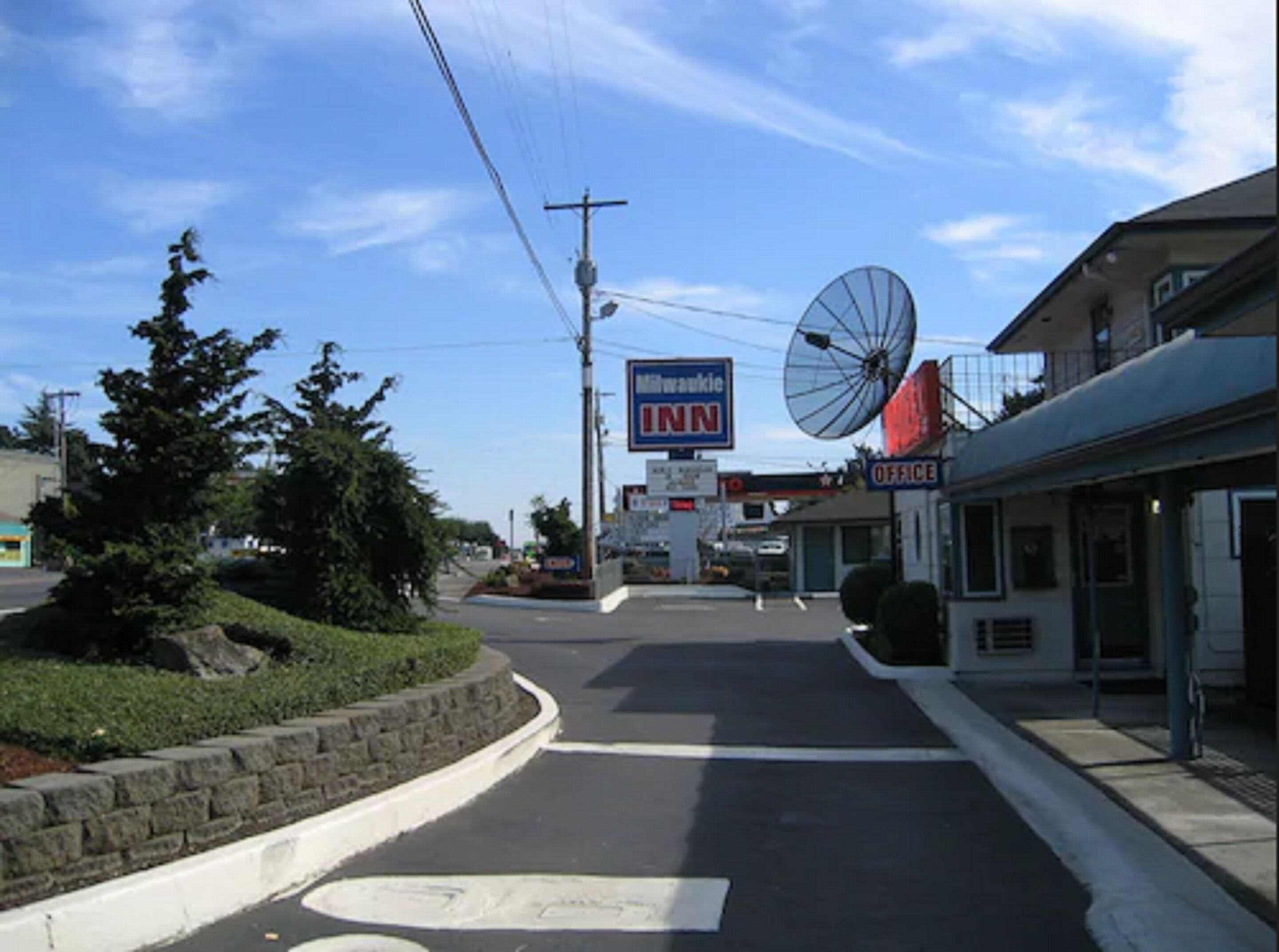 A road leading to a building with an INN sign, a satellite dish, and a visible office sign.
