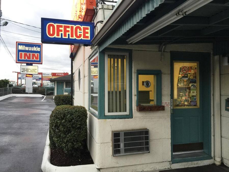A small office building with a sign reading "OFFICE" and a window displaying various items.