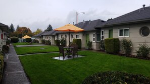 A residential area with well-maintained lawns, a patio with outdoor furniture, and houses with distinct architectural styles. - Milwaukie Inn Portland South (Milwaukie)