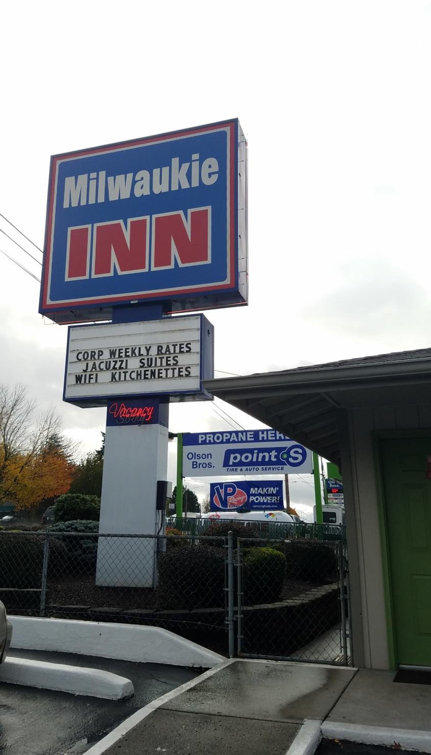 A sign for Milwaukee Inn with a list of amenities including weekly rates, Jacuzzi suites, WiFi, and kitchenettes.