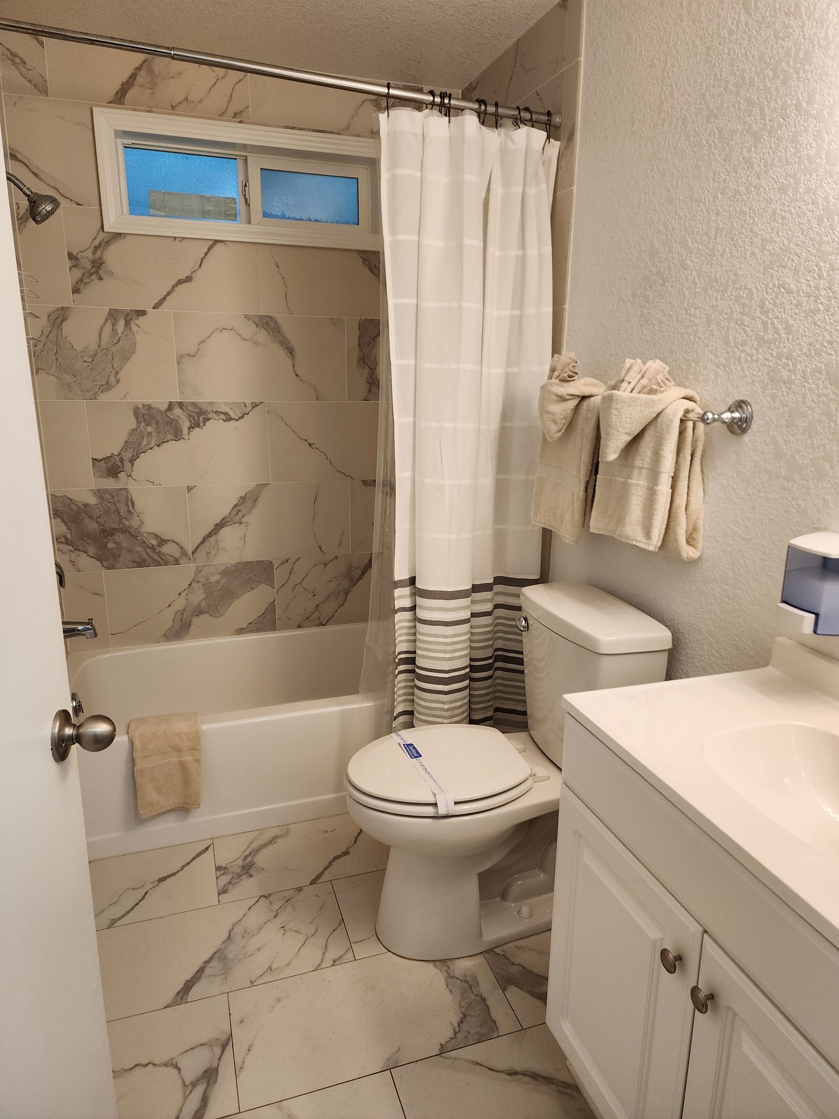 A bathroom with a bathtub, toilet, and vanity.