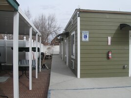 A building with a 'RESERVED PARKING' sign, a fire extinguisher, and a covered outdoor area with tables and chairs.