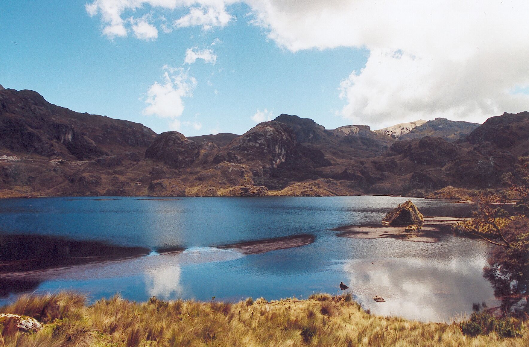 Un lac paisible, entouré de montagnes escarpées et d’une végétation luxuriante.