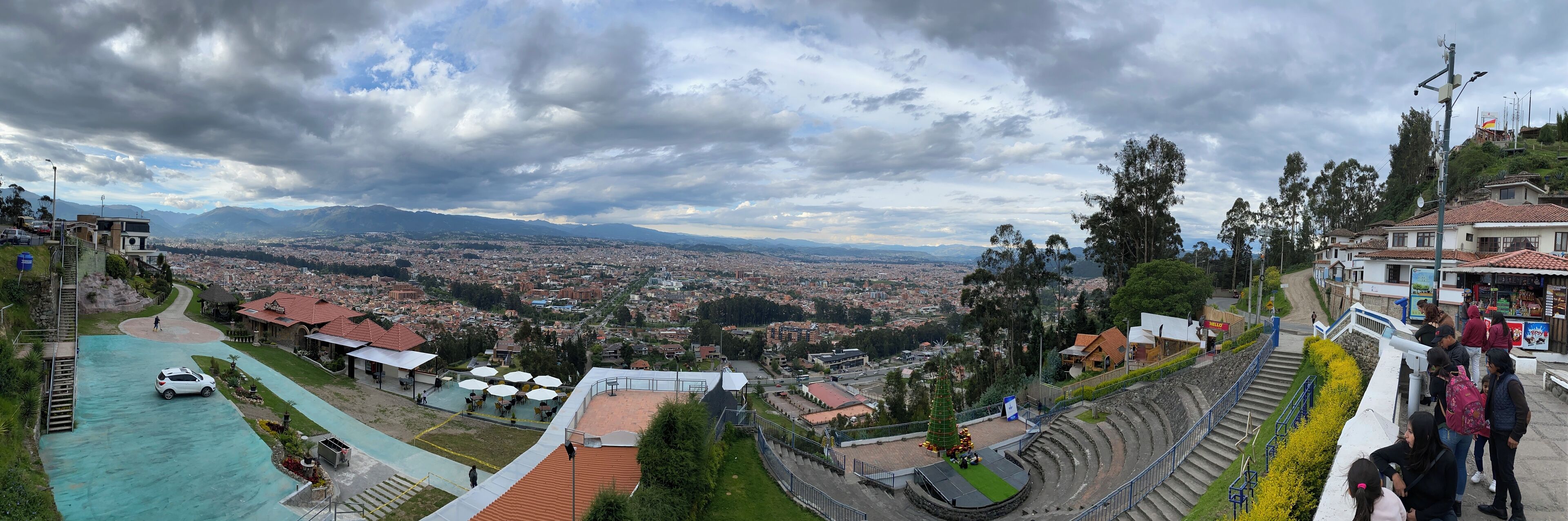 A panoramic view of a city with a large open plaza, a stage, and a viewing platform.