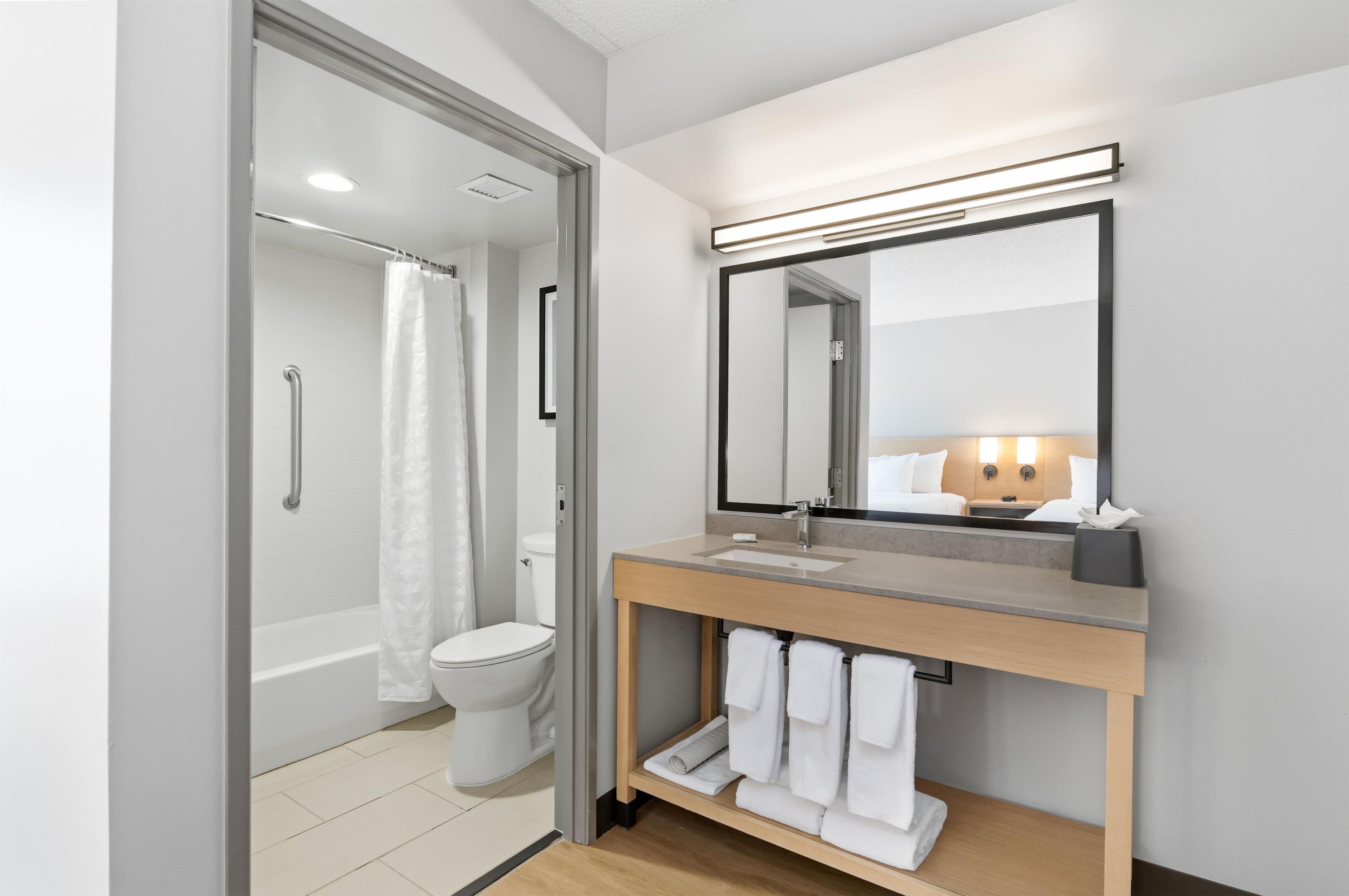 A modern bathroom with a shower, toilet, and vanity.