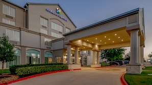 A Hyatt Place hotel with a covered entrance, multiple windows, and a landscaped area with a red curb. - Hyatt Place College Station (College Station)