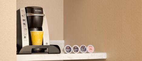 A kitchenette with a microwave, coffee maker, and refrigerator.