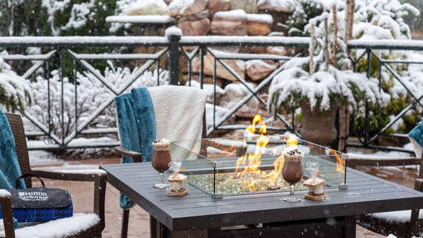 A glass-top table with a built-in fire feature, surrounded by chairs and a bag labeled "Hilton Garden Inn". - Hilton Garden Inn Niagara-on-the-Lake (Niagara-on-the-Lake)