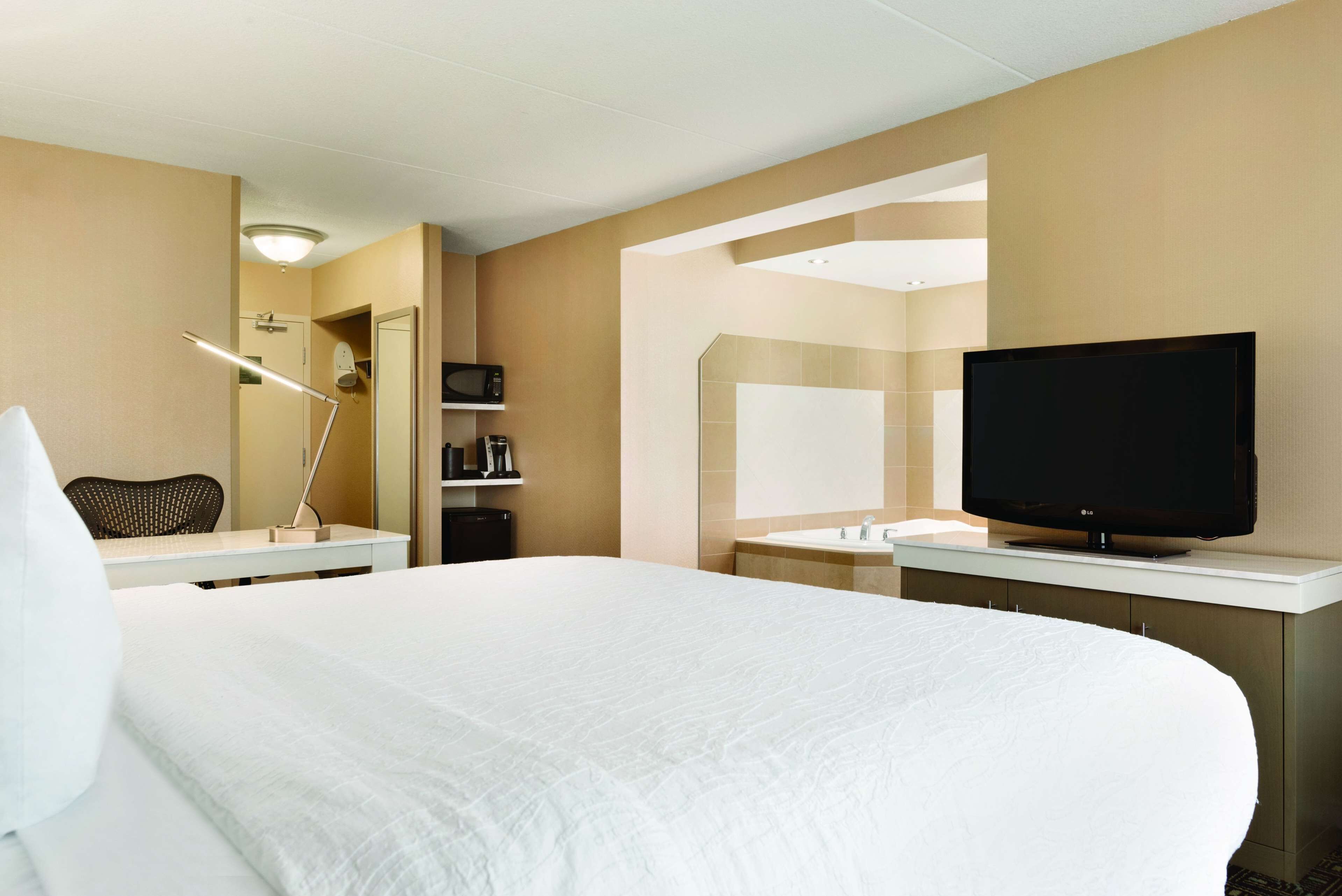 room, 1 king bed, jetted tub | premium bedding, desk, blackout curtains, iron/ironing board