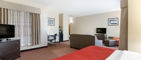 Une chambre d’hôtel équipée d’un lit, d’un bureau, d’une chaise, d’une télévision et d’une petite table.