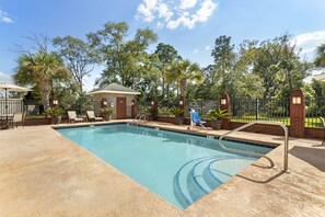 A rectangular pool with a tiled edge, surrounded by a sandy deck. There are lounge chairs and a small building with a sloped roof. - Best Western Plus Bradbury Inn & Suites (Waycross)