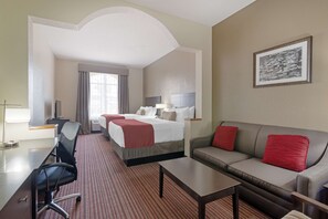 A hotel room with a bed, a sofa, a desk, and a chair. - Best Western Plus Bradbury Inn & Suites (Waycross)