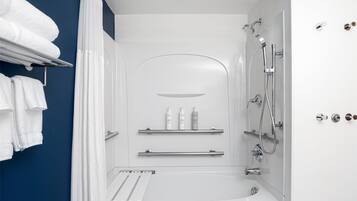 Un baño moderno con bañera, ducha y perchero para toallas.
