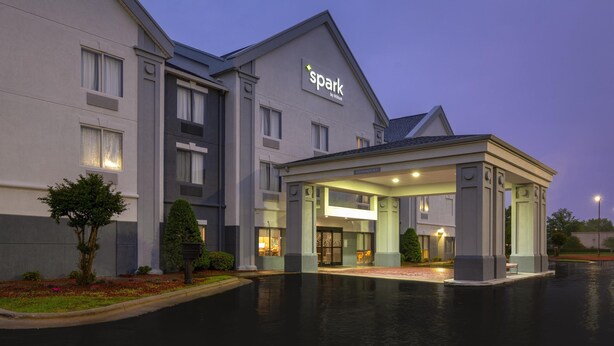 Un hotel de diseño moderno, con entrada cubierta y un cartel que dice "spark by Hilton".