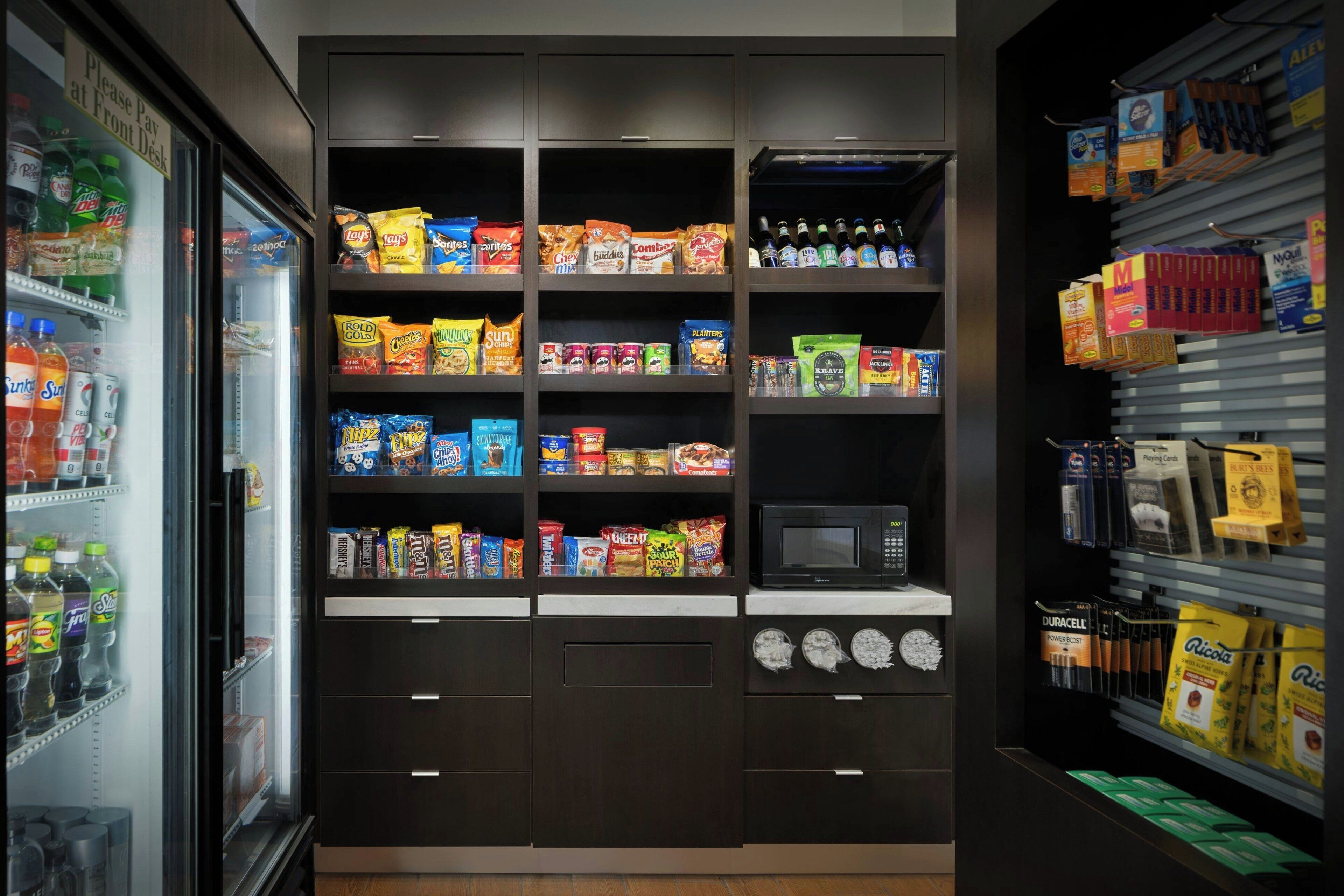 A vending machine area with snacks, drinks, and a microwave.