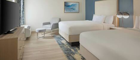 A hotel room with two beds, a TV, a desk, a chair, and a large window with curtains.