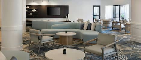 A modern lounge area with a sectional sofa, armchairs, and a coffee table.
