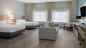 A hotel room with two beds, a sofa, a desk, and a TV. - Wyndham Garden Otsego-Minneapolis (Elk River)