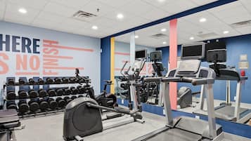 A gym with treadmills, dumbbells, and a motivational wall.