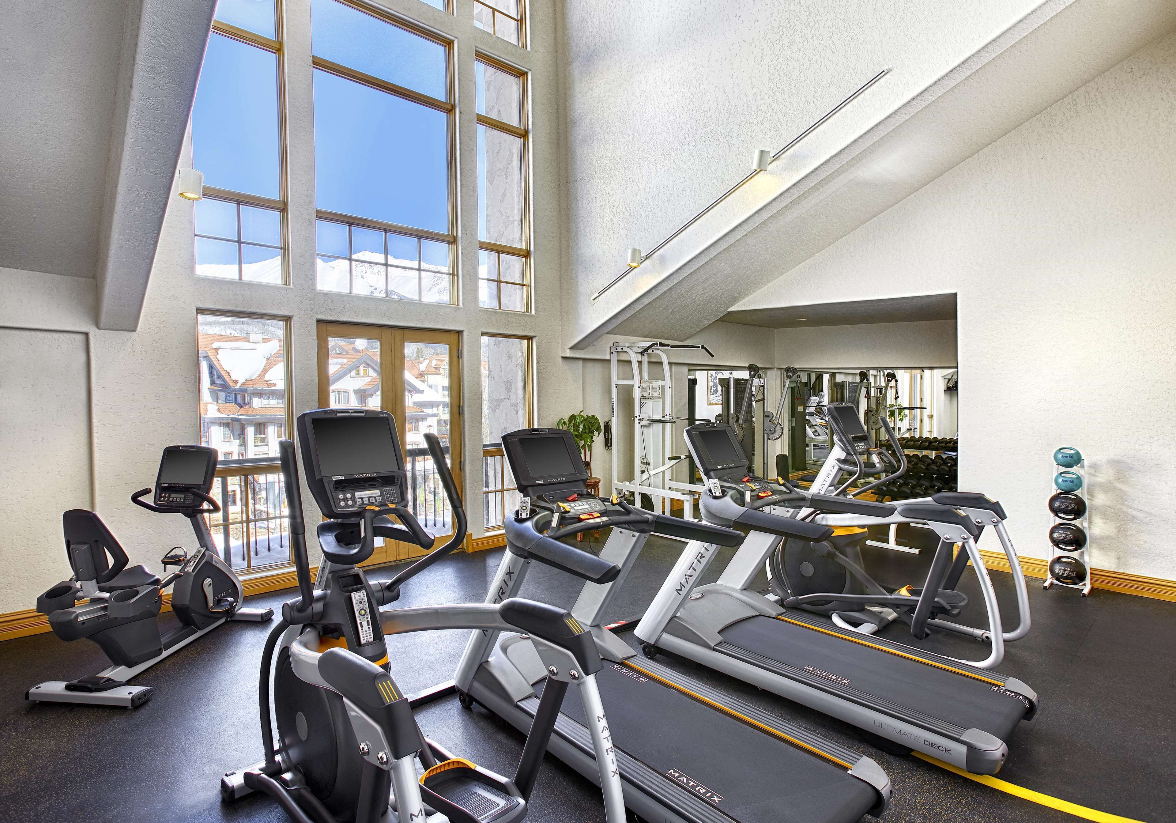 A gym with treadmills, elliptical machines, and weight equipment.