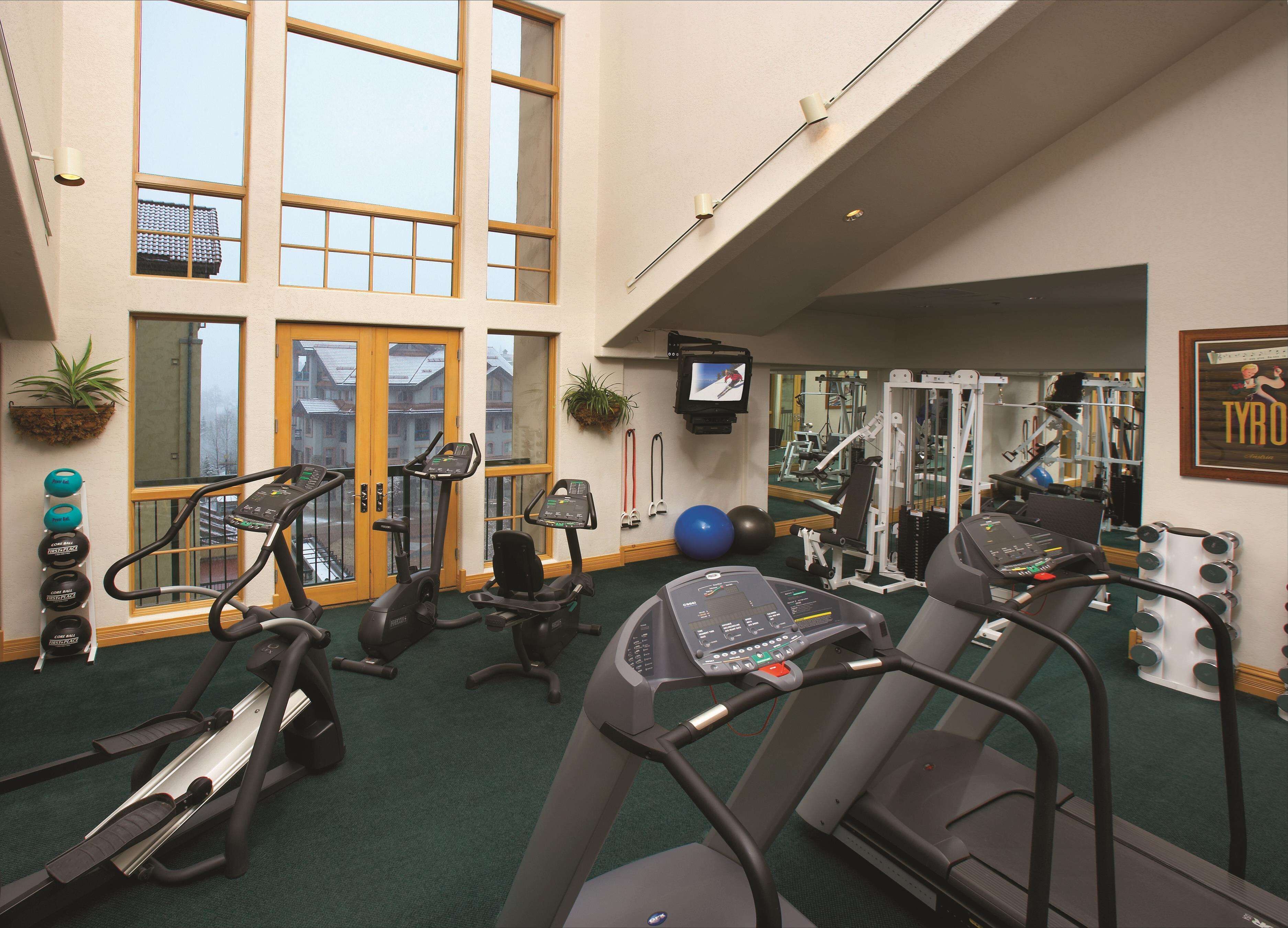 A gym with treadmills, elliptical machines, and weight equipment.