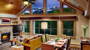 A cozy interior with a fireplace, leather seating, a dining area, and large windows offering mountain views. - Fairmont Heritage Place, Franz Klammer Lodge (Telluride)